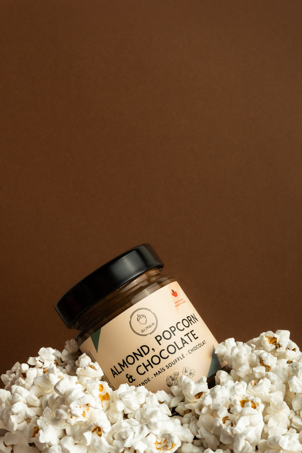 Aupralin almond popcorn chocolate spread diagonally placed among popcorn 